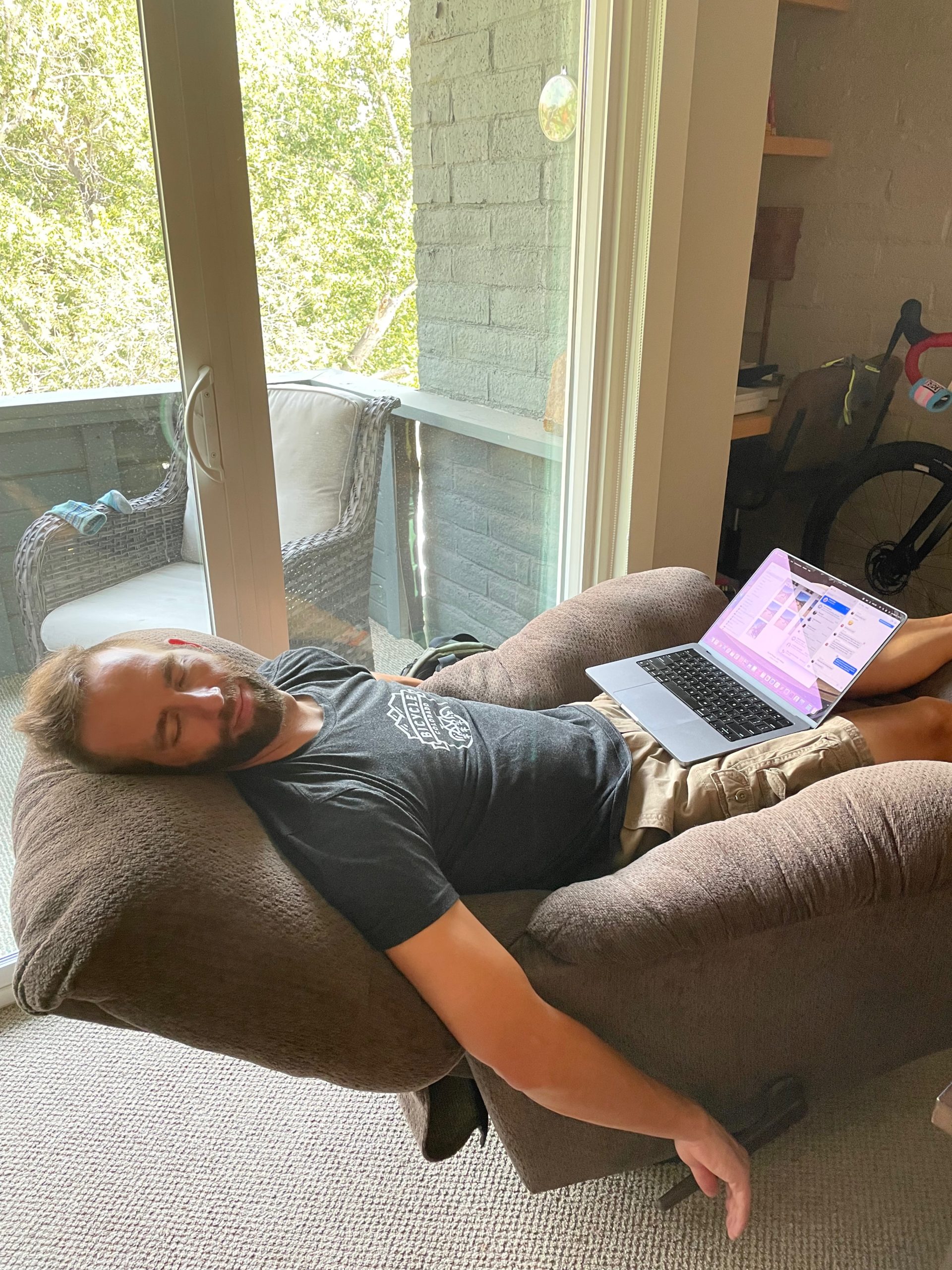 Man rests in recliner with laptop